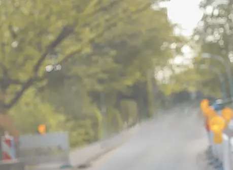 Smartphone scannt eine gelbe Warnleuchte auf einer Baustelle. Symbolbild für digitale Erfassung, Baustellenmanagement und smarte Infrastruktur