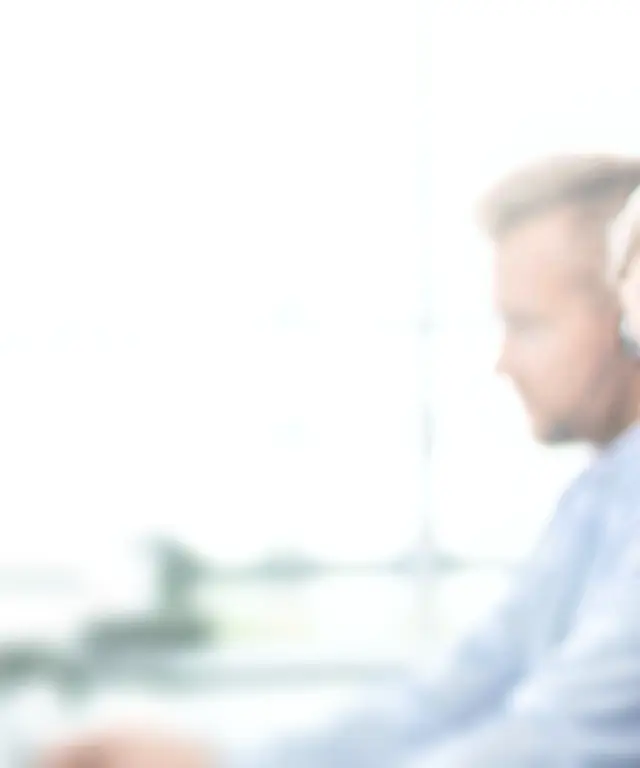 Callcenter‑Mitarbeitende mit Headsets arbeiten konzentriert an ihren Plätzen. Symbolbild für Kundenservice, Support und Kommunikation.