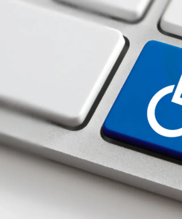 Computertastatur mit blauem Rollstuhlsymbol auf einer Taste – Symbol für digitale Barrierefreiheit, Inklusion und zugängliche Webservices.
