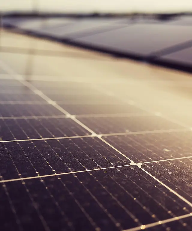 Mehrere Solarpaneele auf dem Dach eines modernen Gebaeudes, Himmel mit Wolken im Hintergrund